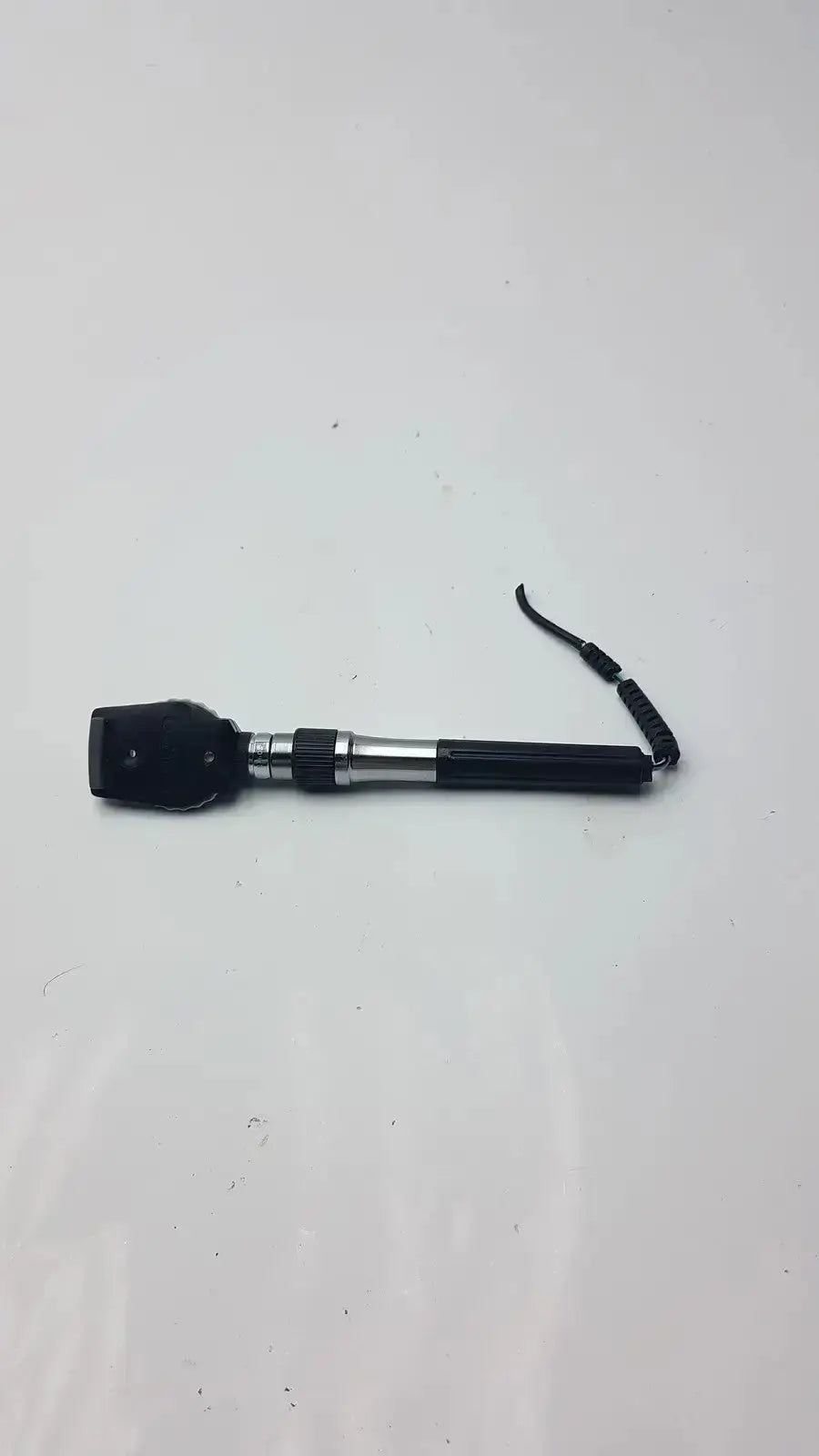 Black and silver welch allyn ophthalmoscope head with coiled black strap for hospital surplus use