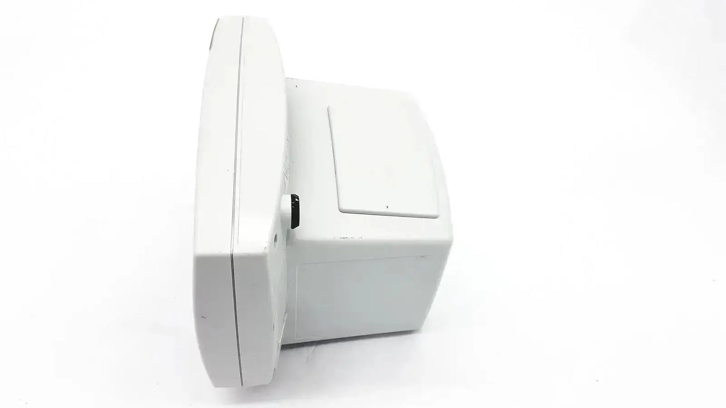 White plastic wall-mounted security camera with rectangular body and black button on side shown with welch allyn vital signs monitor