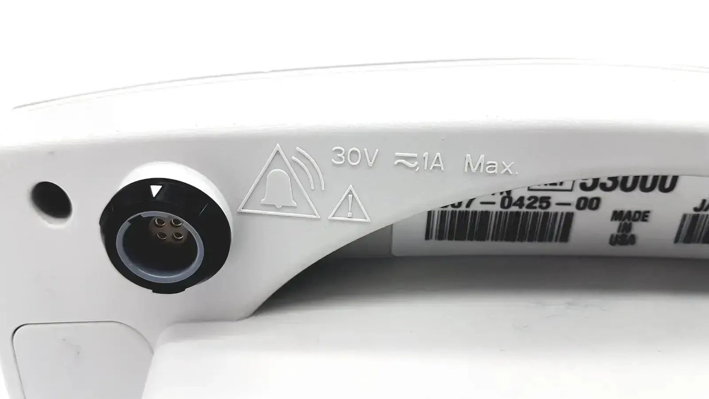 Back side of a white plastic power input port with black circular cover and safety markings on welch allyn vital signs monitor
