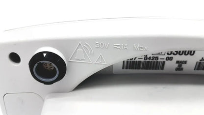 Back side of a white plastic power input port with black circular cover and safety markings on welch allyn vital signs monitor