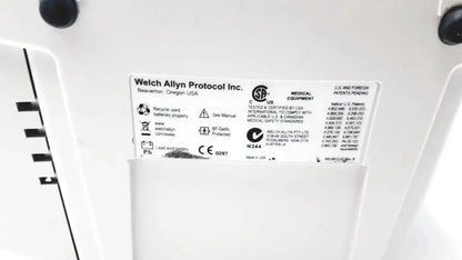 White plastic label with black text and symbols showing welch allyn protocol inc on welch allyn 530t0 patient monitor