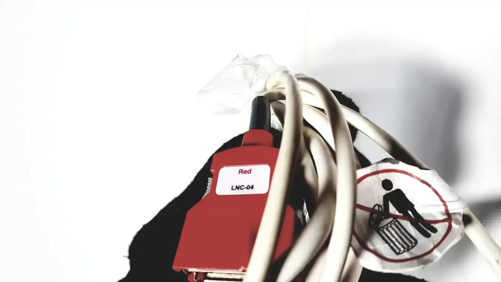 Red lnc-04 connector with black tip wrapped in white cables on the back of welch allyn connex vital signs monitor 6000 series