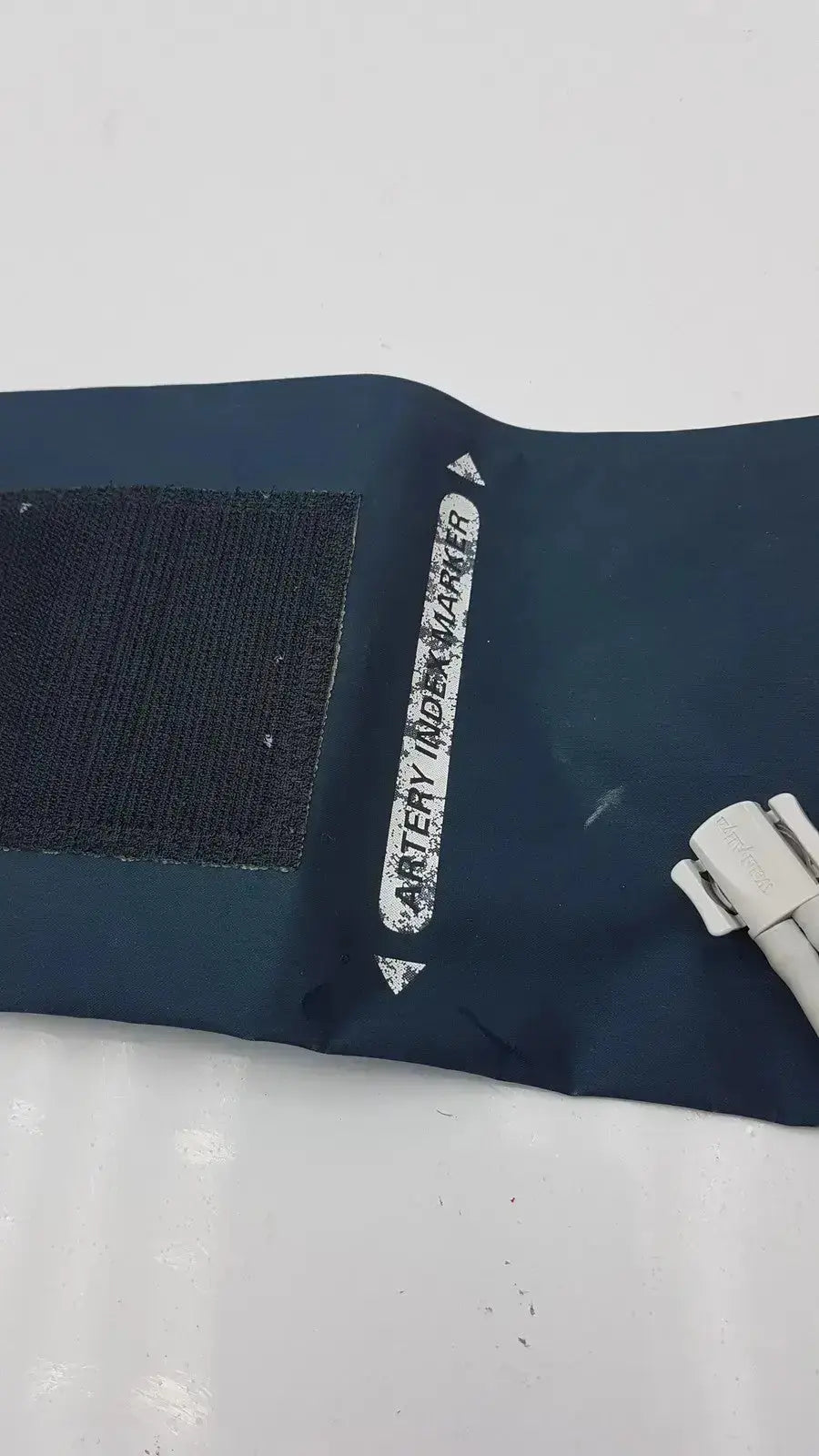 Dark blue welch allyn flexiport reusable adult blood pressure cuff with black velcro and artery index marker label