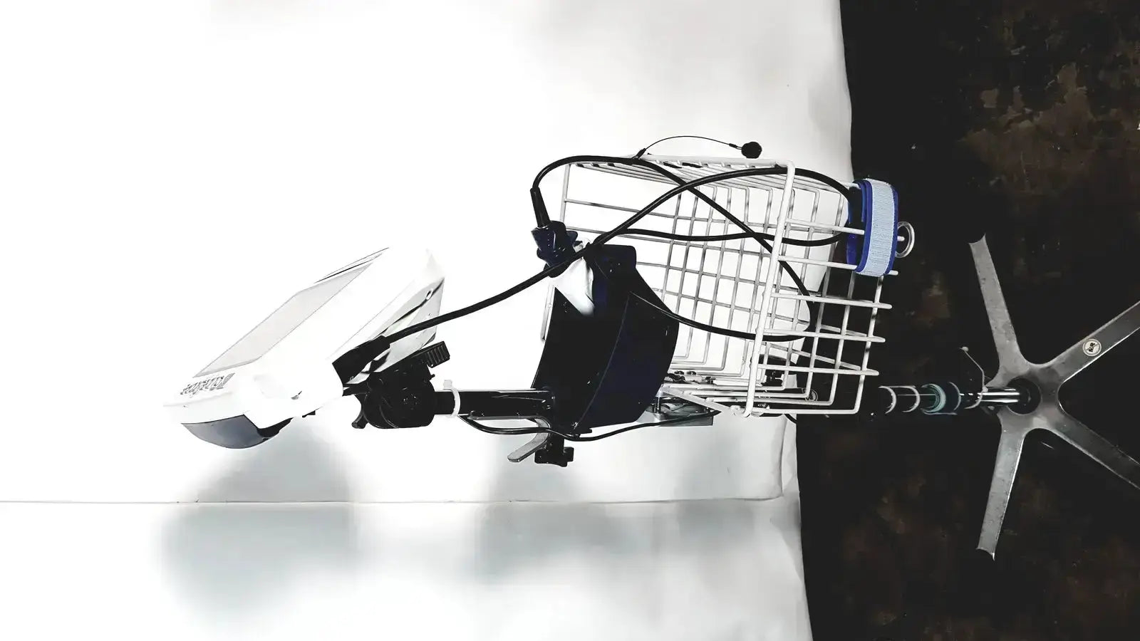 White wire basket mounted on bicycle handlebar with black cables and blue white cylinder in welch allyn glidescope cobalt avl