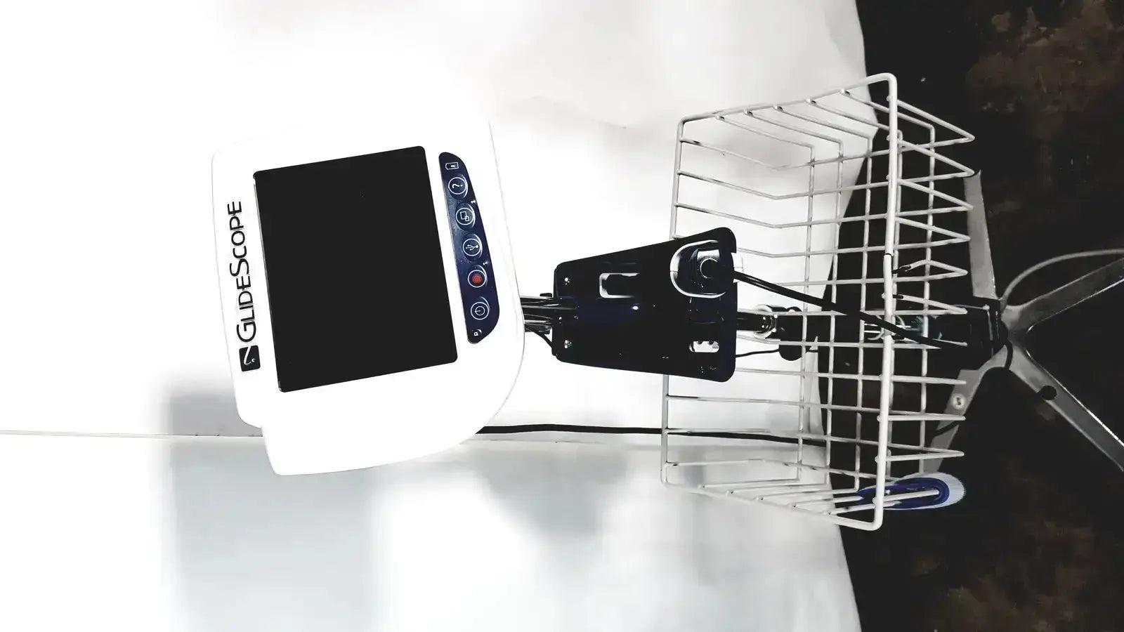 White Welch Allyn Glidescope Cobalt AVL monitor with black control buttons mounted on bicycle basket digital screen visible