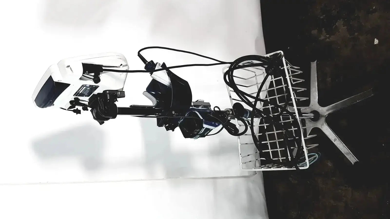 White and black electric outboard motor with attached basket shown alongside welch allyn glidescope cobalt avl monitor cart