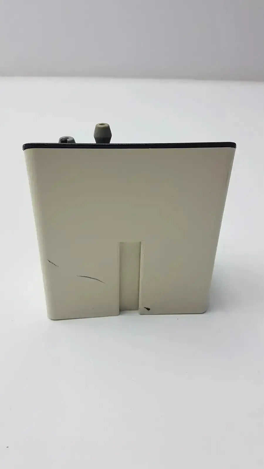 Beige welch allyn model 71123 audio scope charging stand with black top edge and two gray cylindrical protrusions