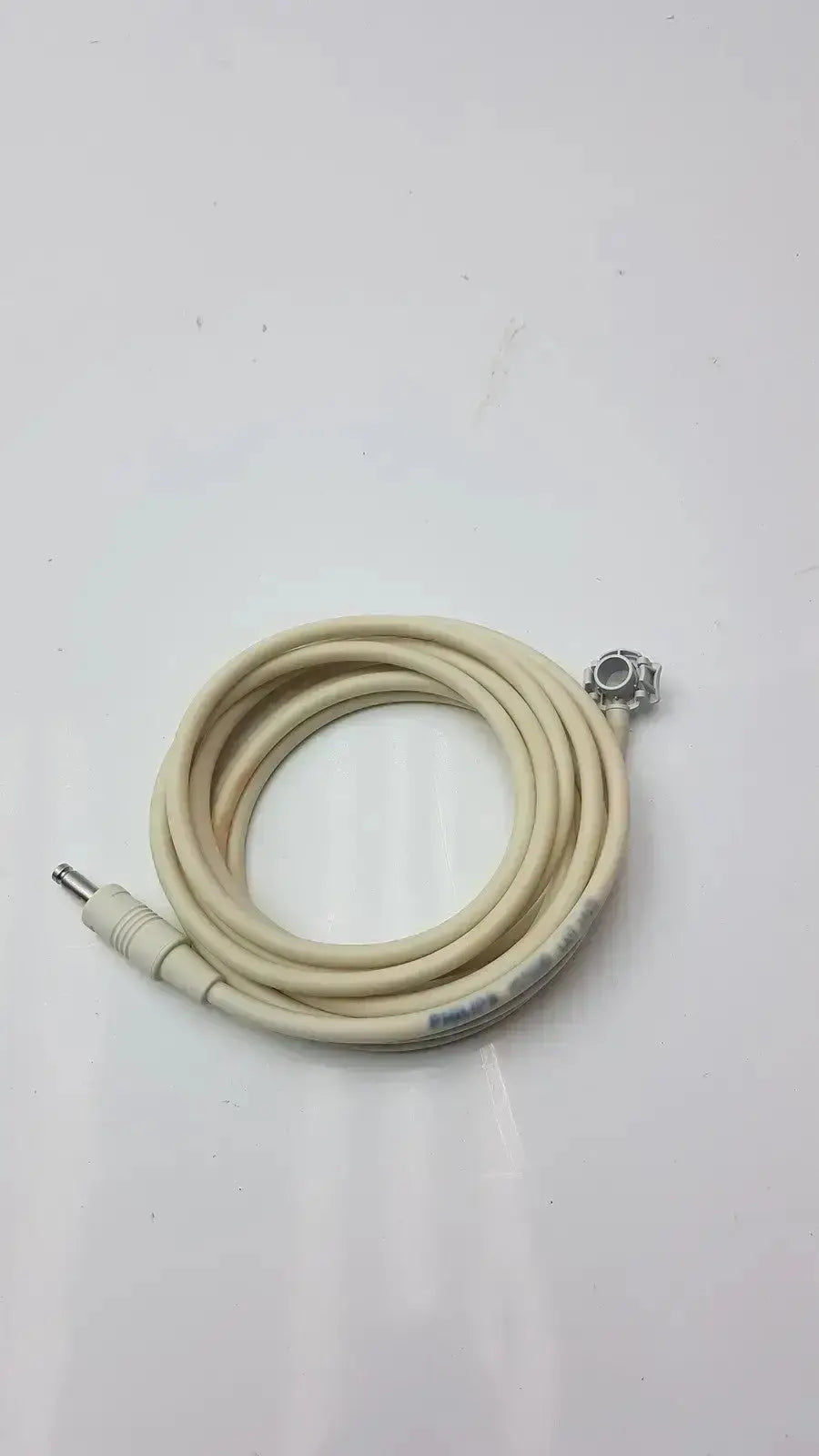 Beige coiled welch allyn patient monitor cable with metallic connectors for reliable patient monitoring use