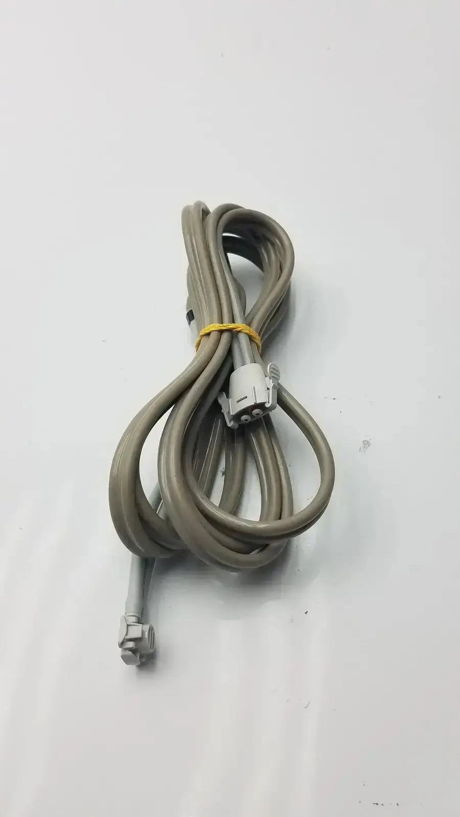 Gray coiled welch allyn double hose with yellow tie and white plastic connectors for used medical equipment sale