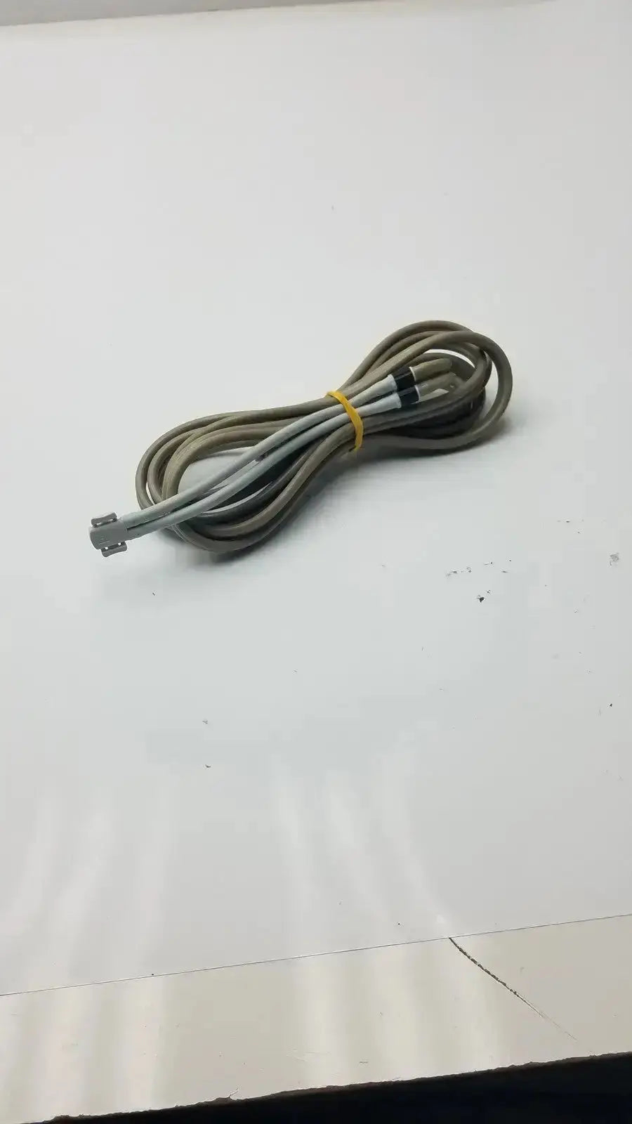 Coiled gray and white welch allyn double hose with yellow tie and rectangular connector for used medical equipment sale