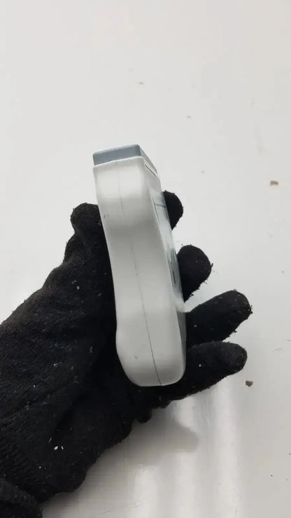 Silver-colored wireless ecg acquisition module held in black-gloved hand for welch allyn digital health monitoring