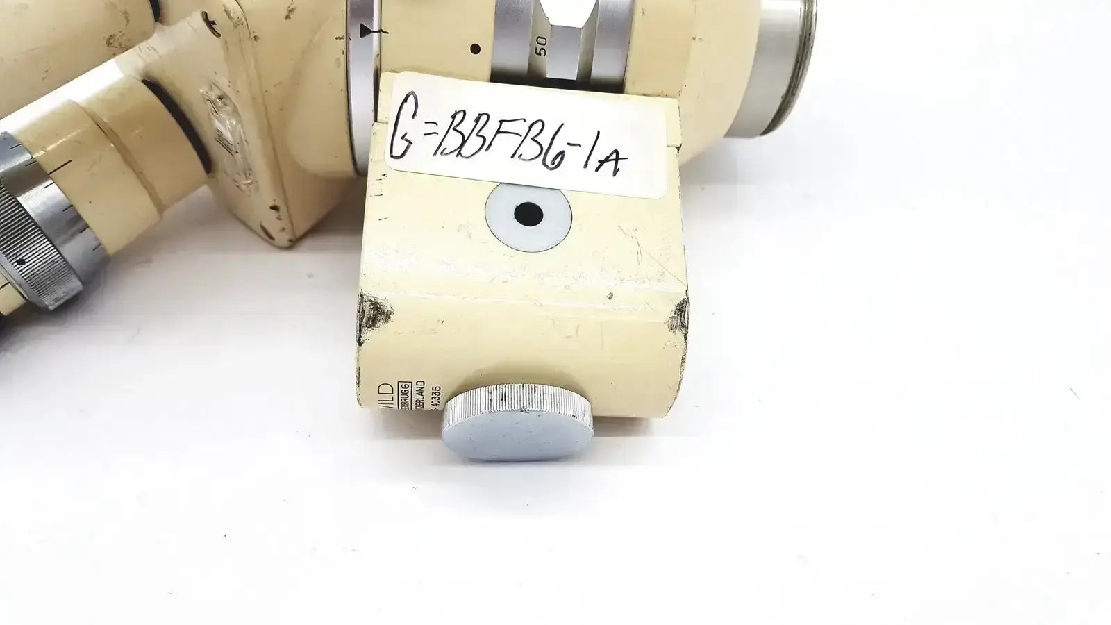 Cream-colored wild heerbrugg m5-26436 microscope objective with silver adjustment knob and engraved serial number label
