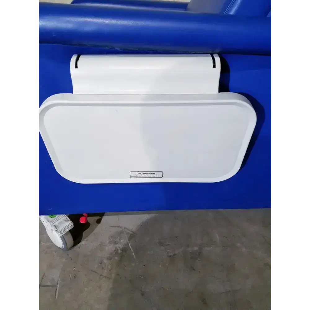 White plastic tray attached to blue medical bed frame of winco 694 care recliner dialysis chair with side trays