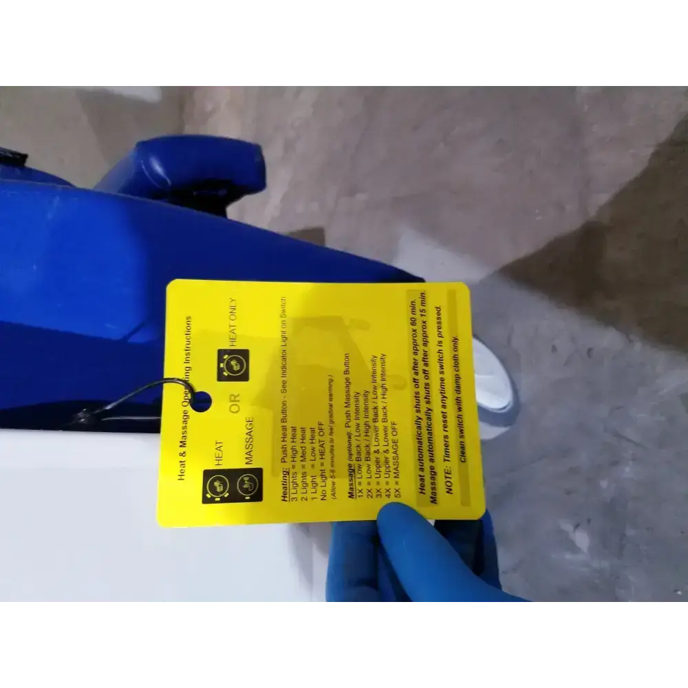 Yellow instruction tag with black text and icons for heat and massage settings on back of winco 694 care recliner dialysis chair