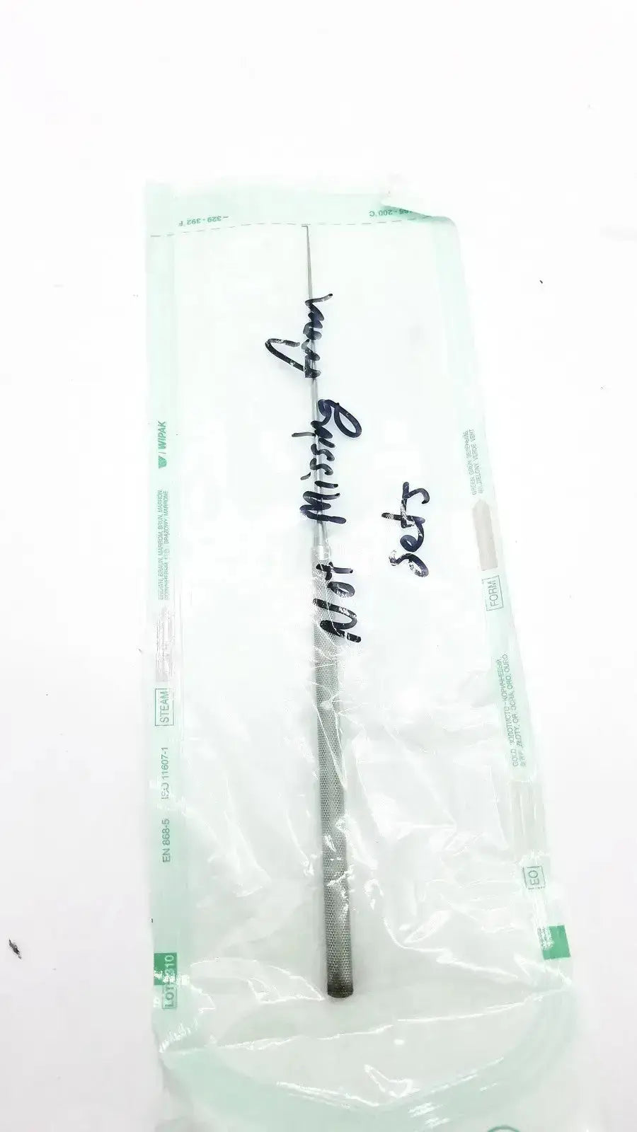 A metallic textured surgical instrument with a slender shaft and darkened tip shown with wipak sterikit sterilization packaging