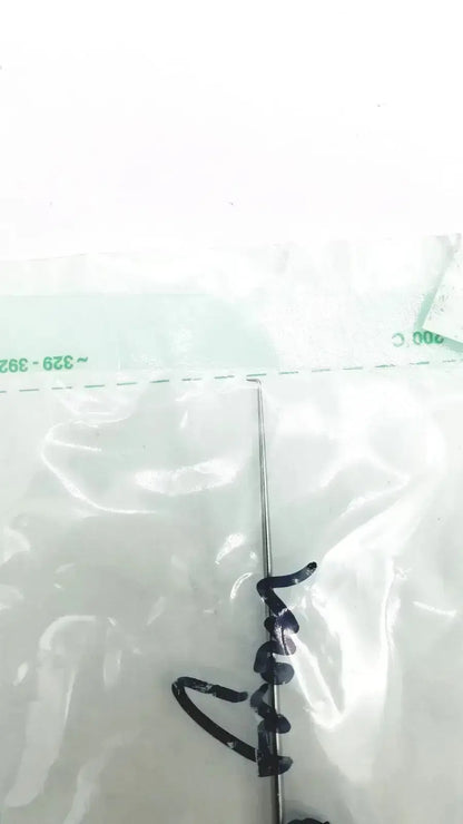 A slender metallic surgical needle with a sharp point and fine thread in wipak sterikit sterilization packaging
