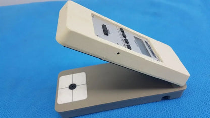 Cream-colored plastic battery operated x-rite 331 transmission densitometer with gray base and black buttons for precision measuring