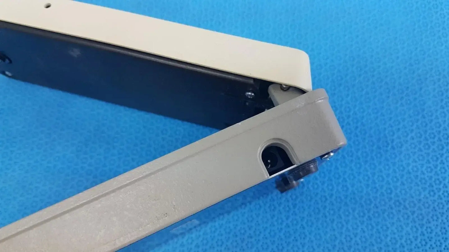 Beige and black plastic clamp with hinge mechanism on x-rite 331 battery operated transmission densitometer medical equipment
