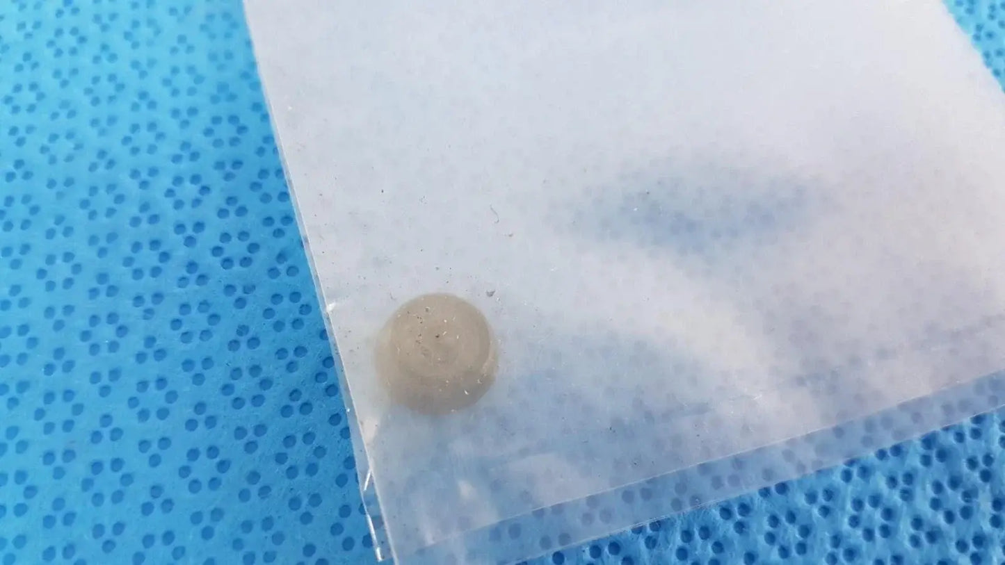 A translucent beige round object with a textured surface in a clear bag for x-rite 331 transmission densitometer medical equipment