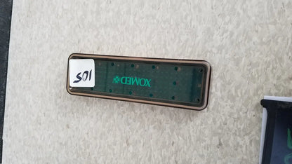 A dark green xomed poly vac medical equipment sterilization case with metallic frame and circular indentations