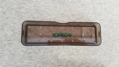 Transparent brown plastic xomed poly vac tray with green logo and circular indentations for reuse medical equipment sterilization