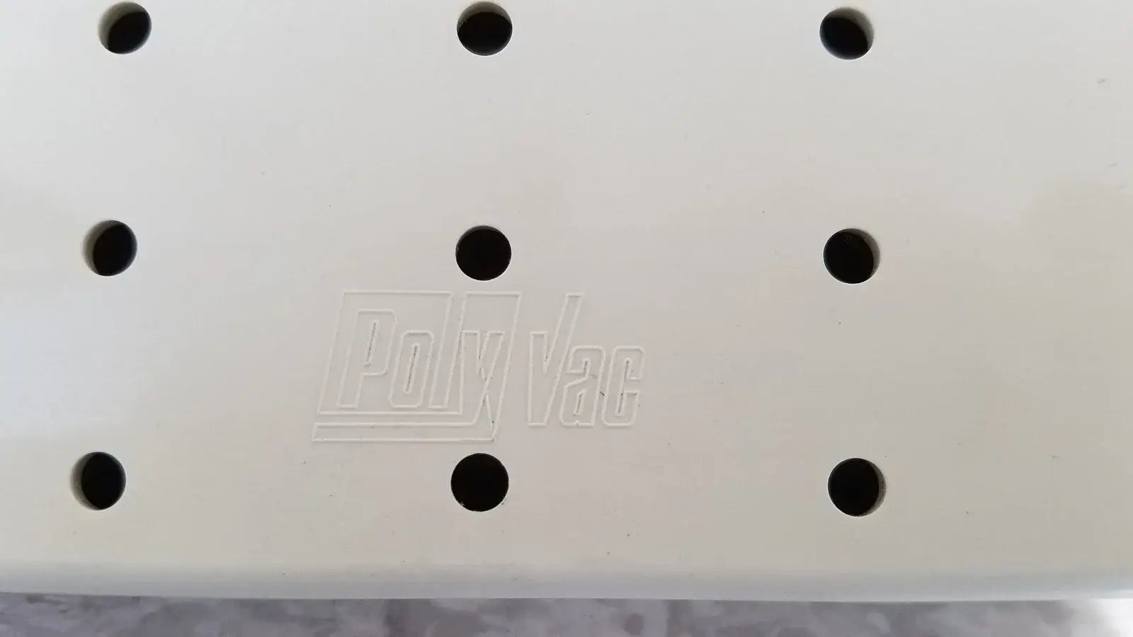 White plastic panel with black circular holes and embossed polyvac logo for xomed poly vac medical equipment sterilization case