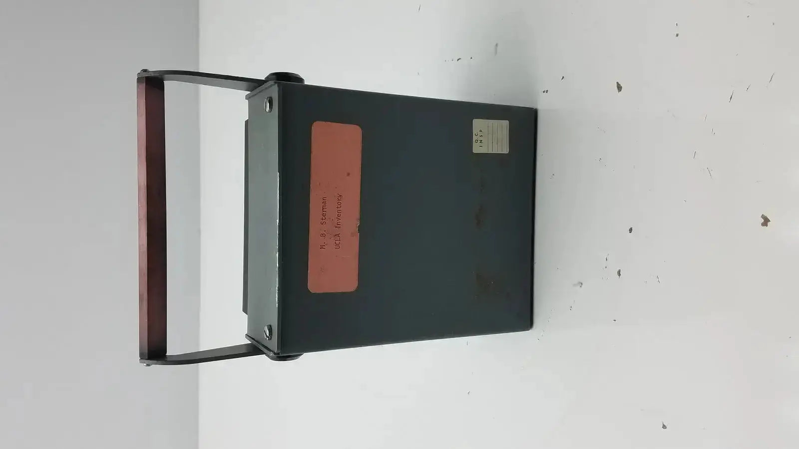 Dark green metal ysi model 42sc tele-thermometer with reddish-brown handle and two labels on the side