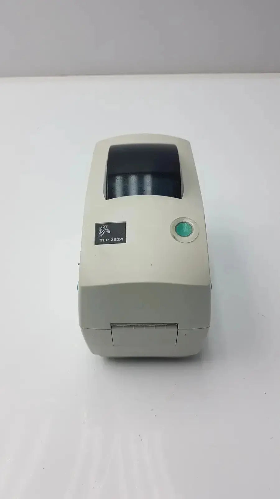 Beige zebra tlp 2824 plus thermal printer with green power button and black paper output slot for label printing