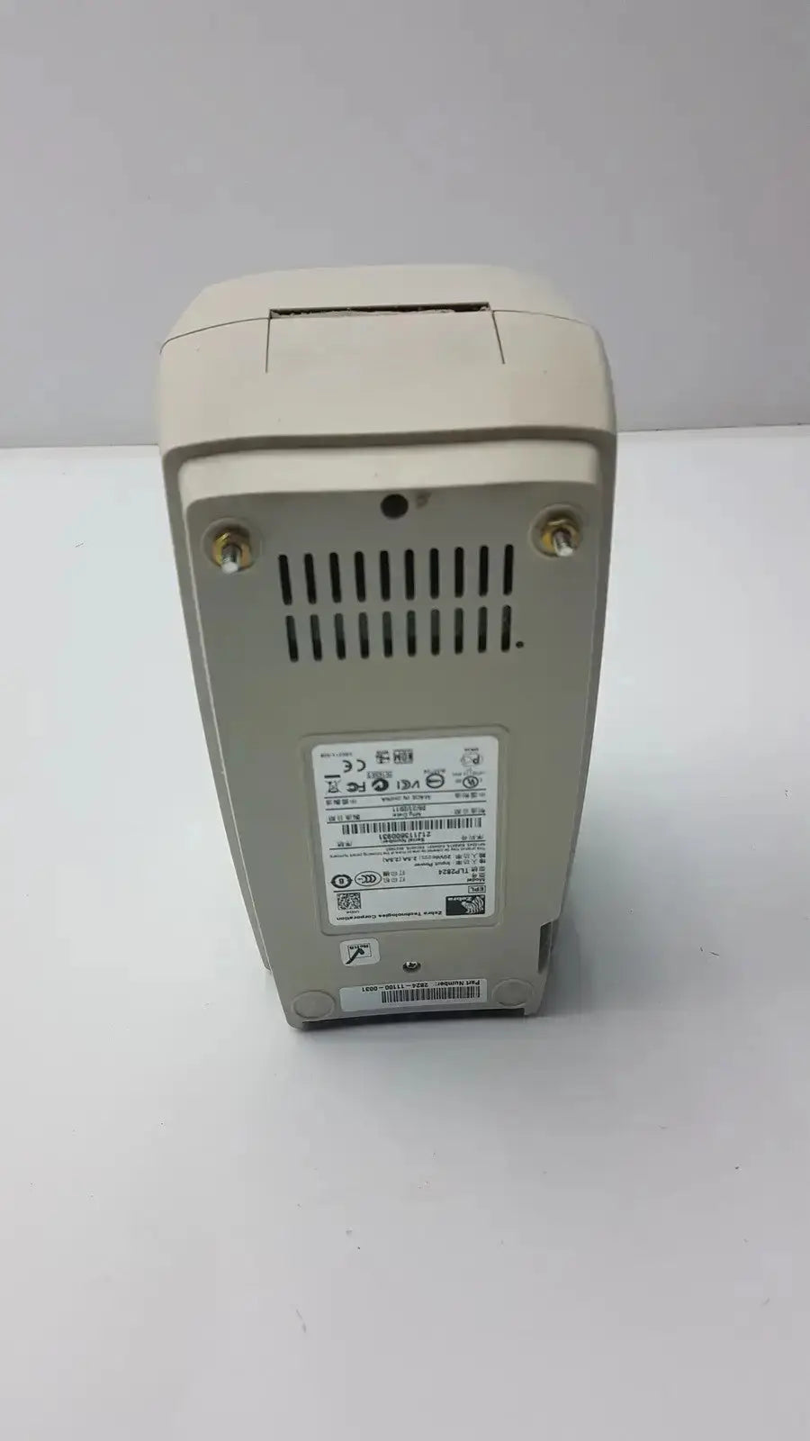 Beige zebra tlp 2824 plus thermal printer back side showing vented panel and metallic screws for cooling and durability