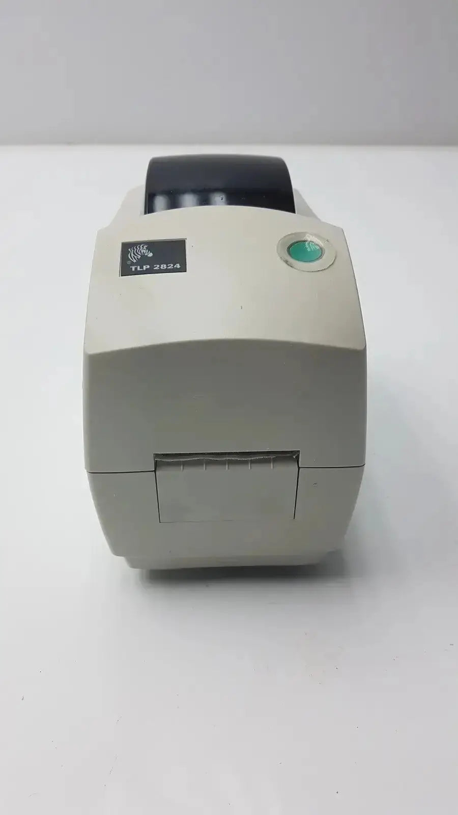 Beige zebra tlp 2824 plus thermal printer with black paper roll and green power button for label printing