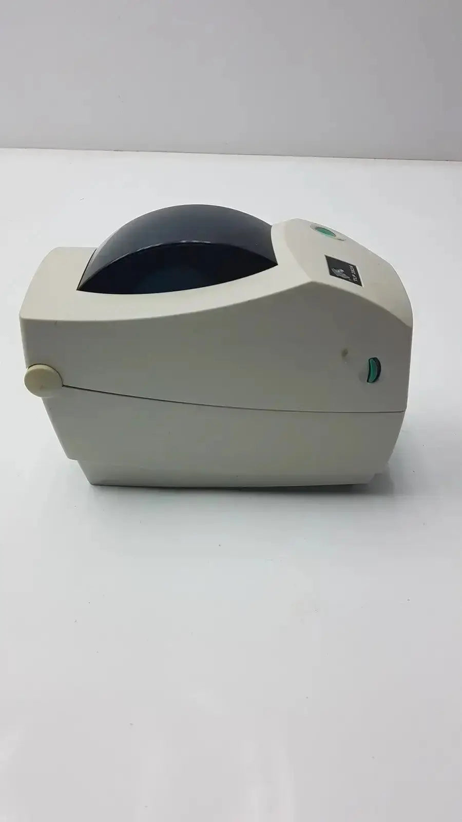 Beige zebra tlp plus thermal printer with dark blue dome cover and green indicator lights for label printing