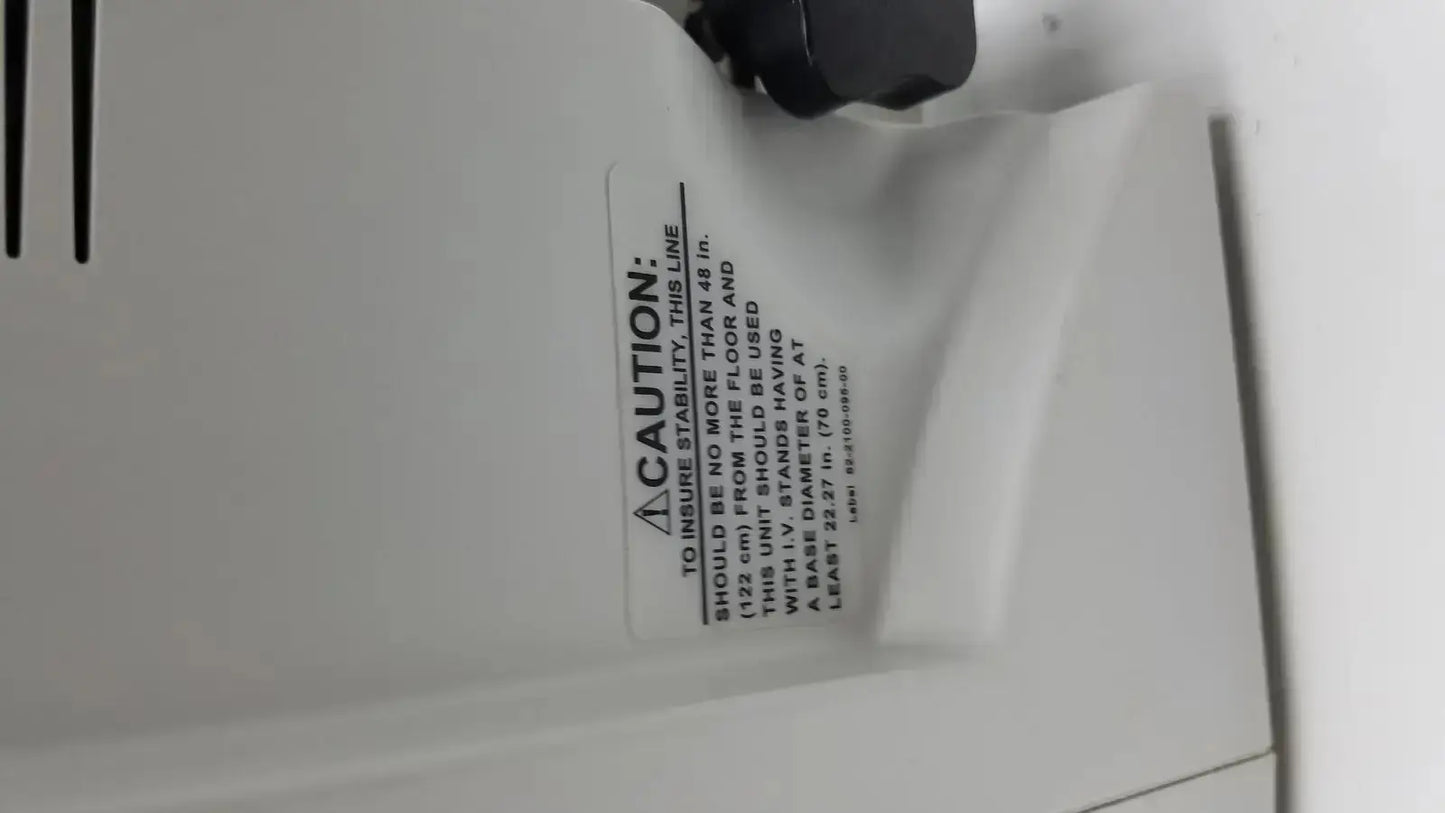 White plastic caution label with black text and warning symbol on the back of the zimmer hall ats 3000 automatic tourniquet system