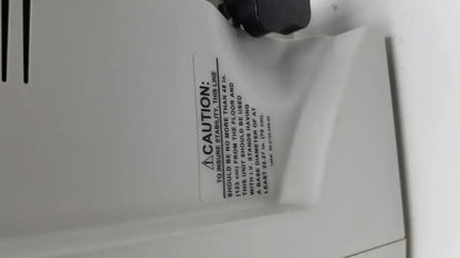 White plastic caution label with black text and warning symbol on the back of the zimmer hall ats 3000 automatic tourniquet system