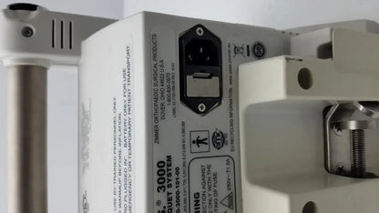 White plastic back side of zimmer hall ats 3000 automatic tourniquet system with power input port and safety warnings