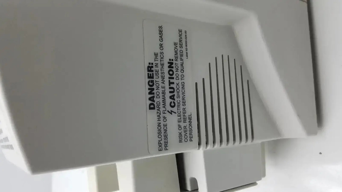 White plastic industrial ventilation unit with vertical slats and warning labels on zimmer hall ats 3000 automatic tourniquet