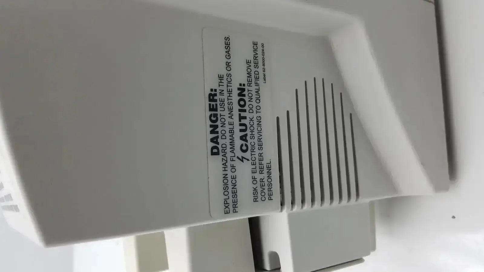 White plastic industrial ventilation unit with vertical slats and warning labels on zimmer hall ats 3000 automatic tourniquet