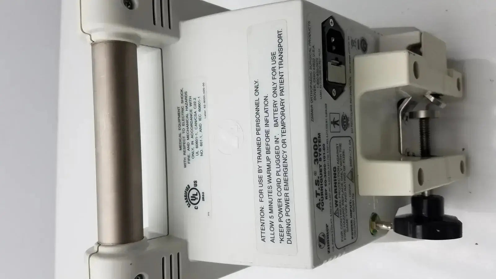 White plastic automatic tourniquet with metallic handle and black knobs labeled a.t.s by zimmer hall ats 3000 system