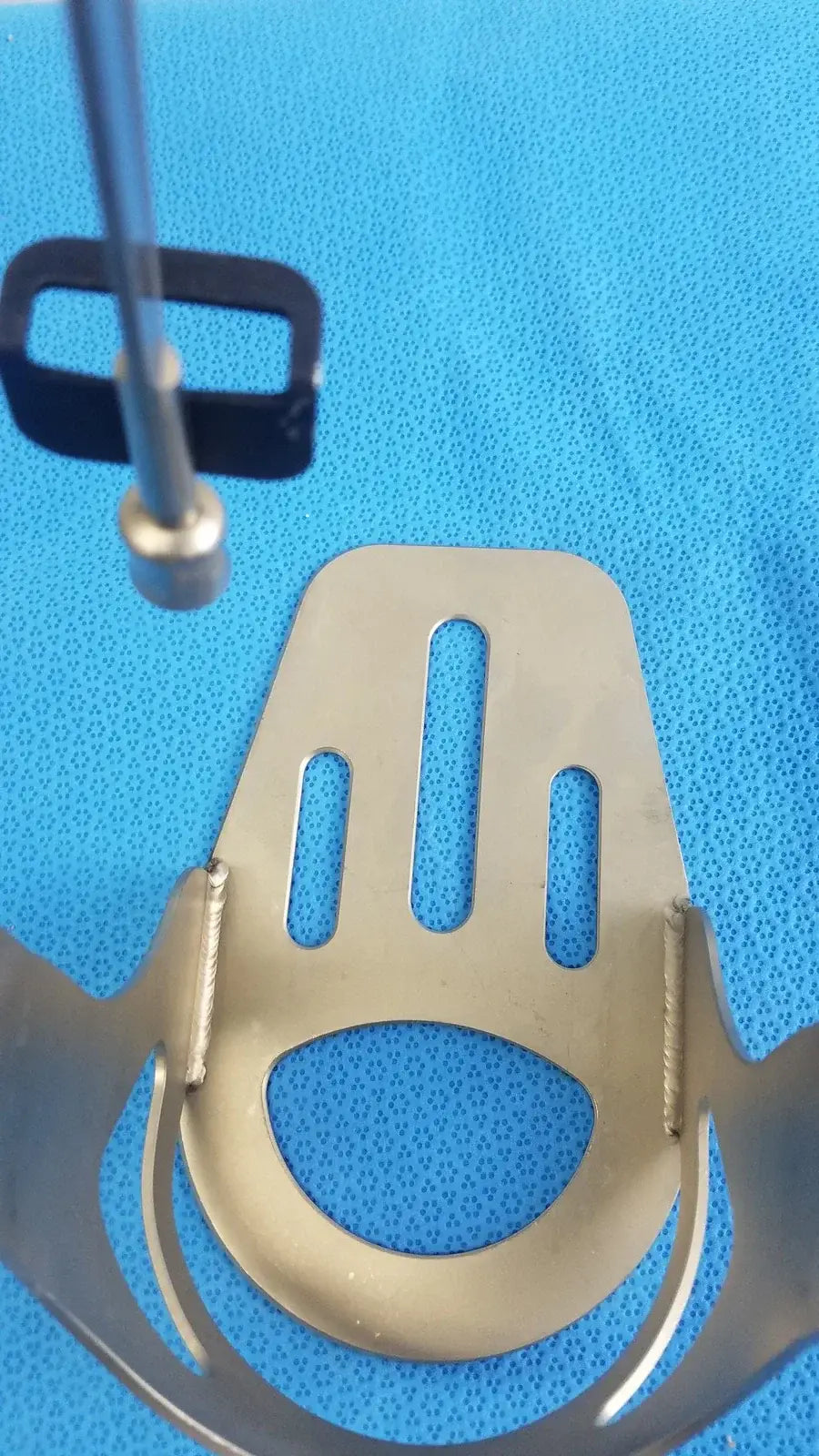 Metallic biomet finneli tensioning boot with curved open end and three vertical slots for reuse medical equipment