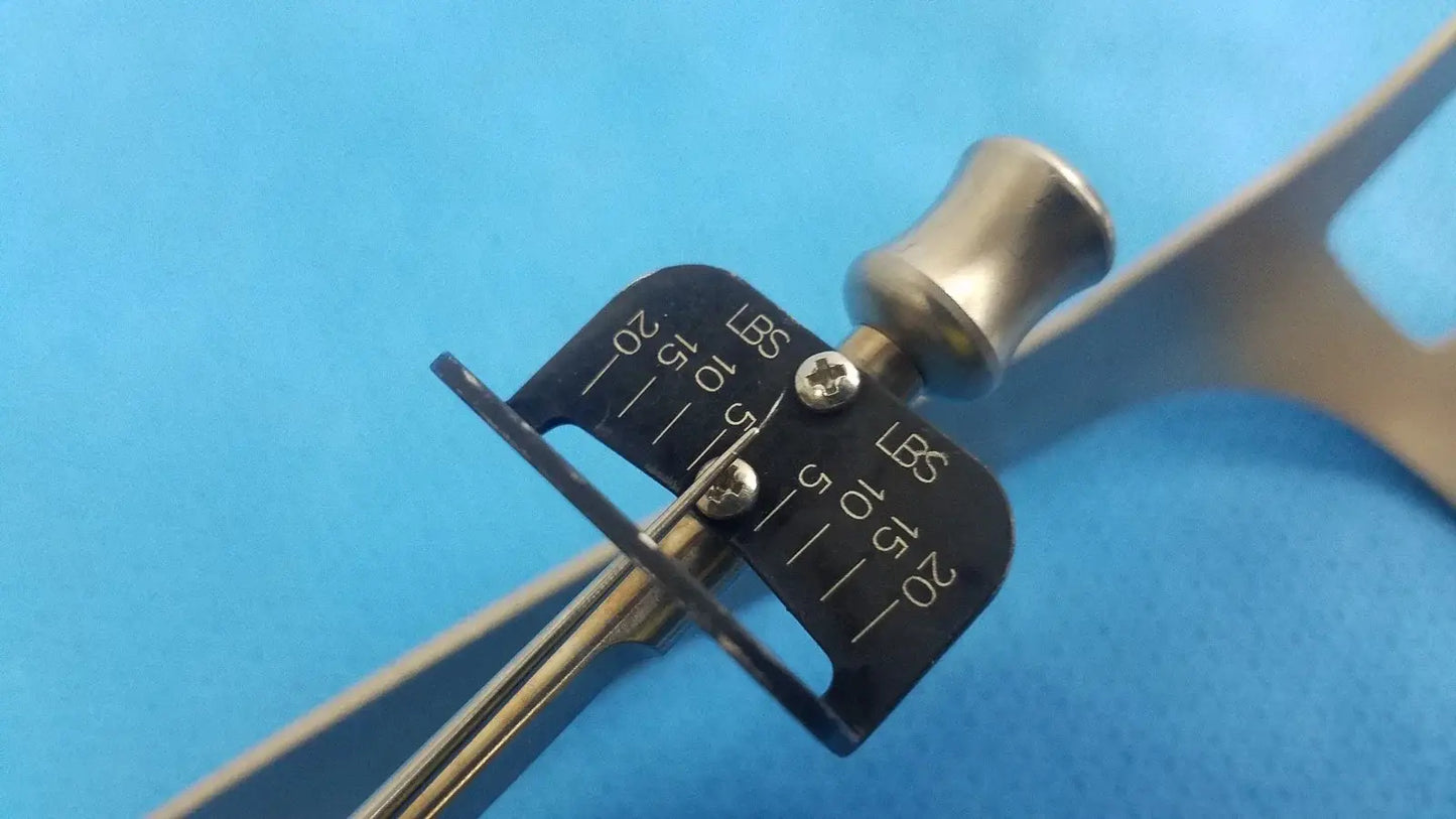 Silver-toned metal caliper with black pound scale and screws on biomet finneli tensioning reuse medical equipment