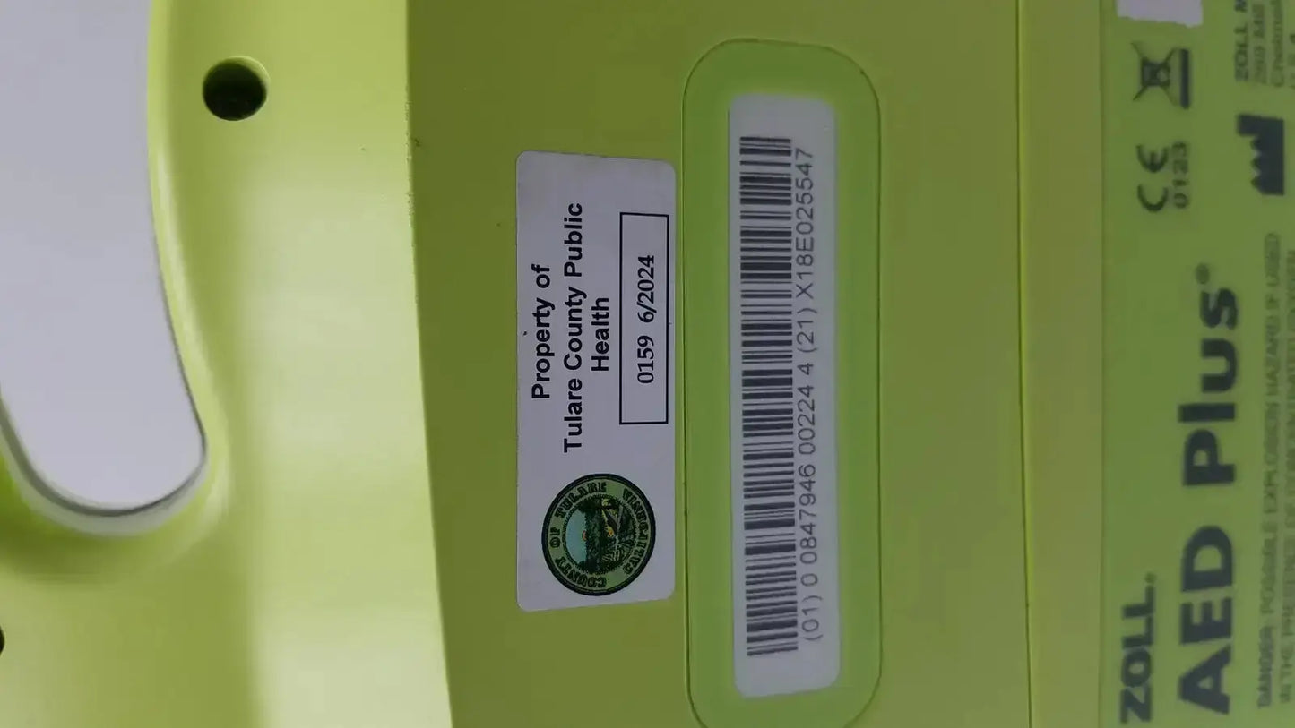 Lime green zoll aed plus automated external defibrillator with barcode and tulare county public health property label