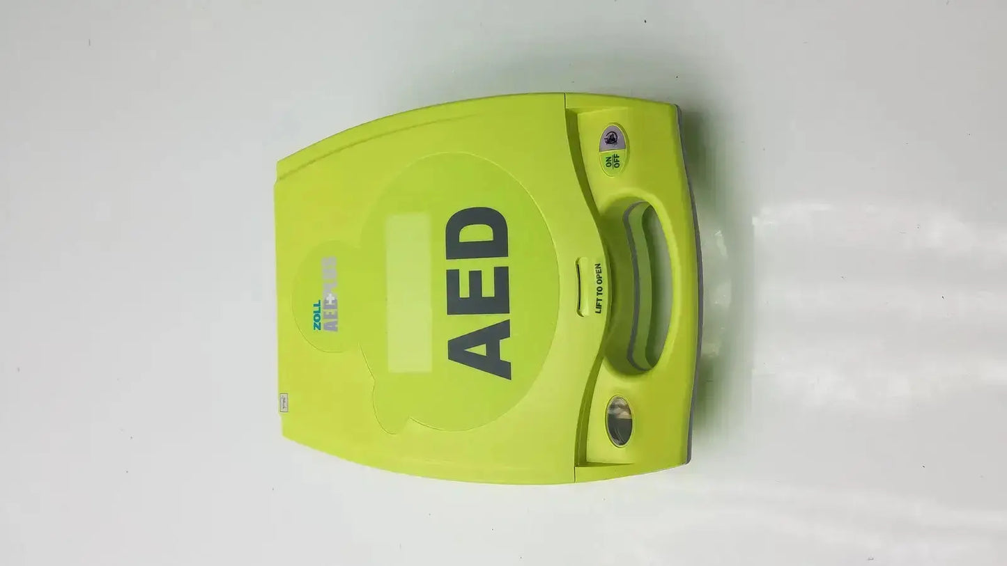 Bright lime green ZOLL AED Plus defibrillator with handle and control panel designed for emergency use