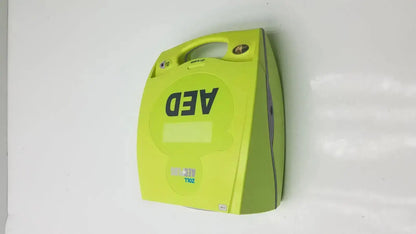 Bright lime green zoll aed plus defibrillator with sturdy plastic casing and integrated handle wall-mounted for quick access