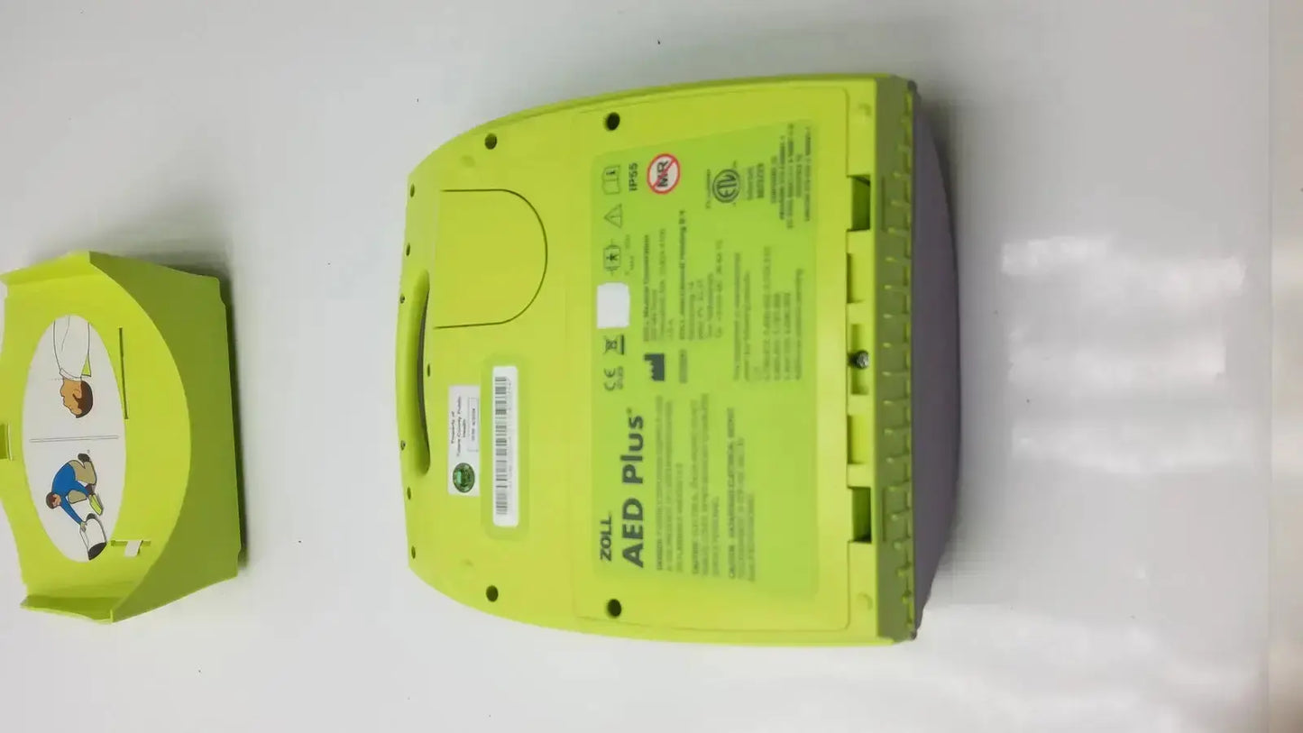 Lime green zoll aed plus automated external defibrillator with molded plastic casing and instructional diagrams on the side