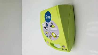 Bright lime green zoll aed plus trainer 2 automated external defibrillator mounted on wall for emergency use